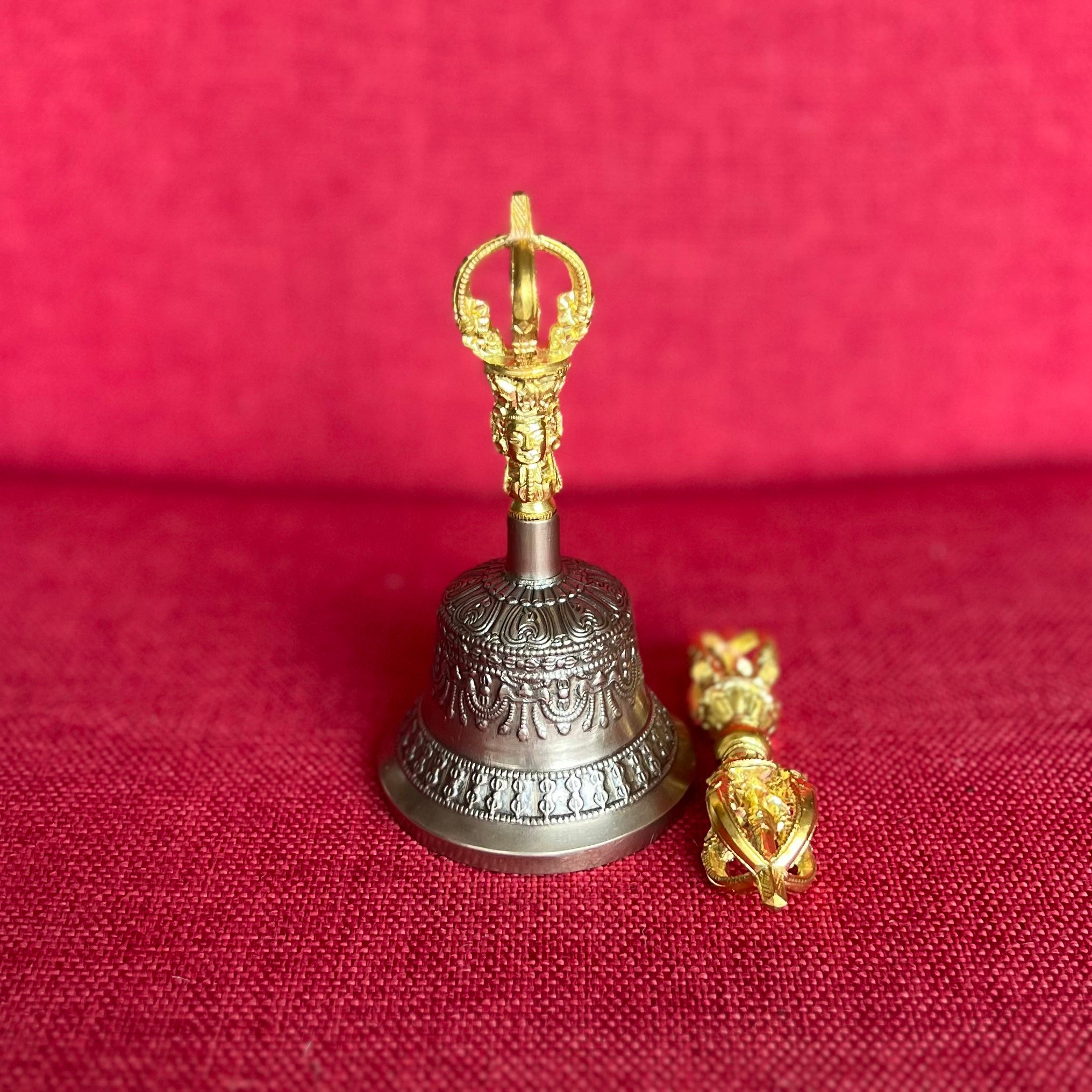 Small bronze Dehradhun-made bell with gold-colored handle and dorje