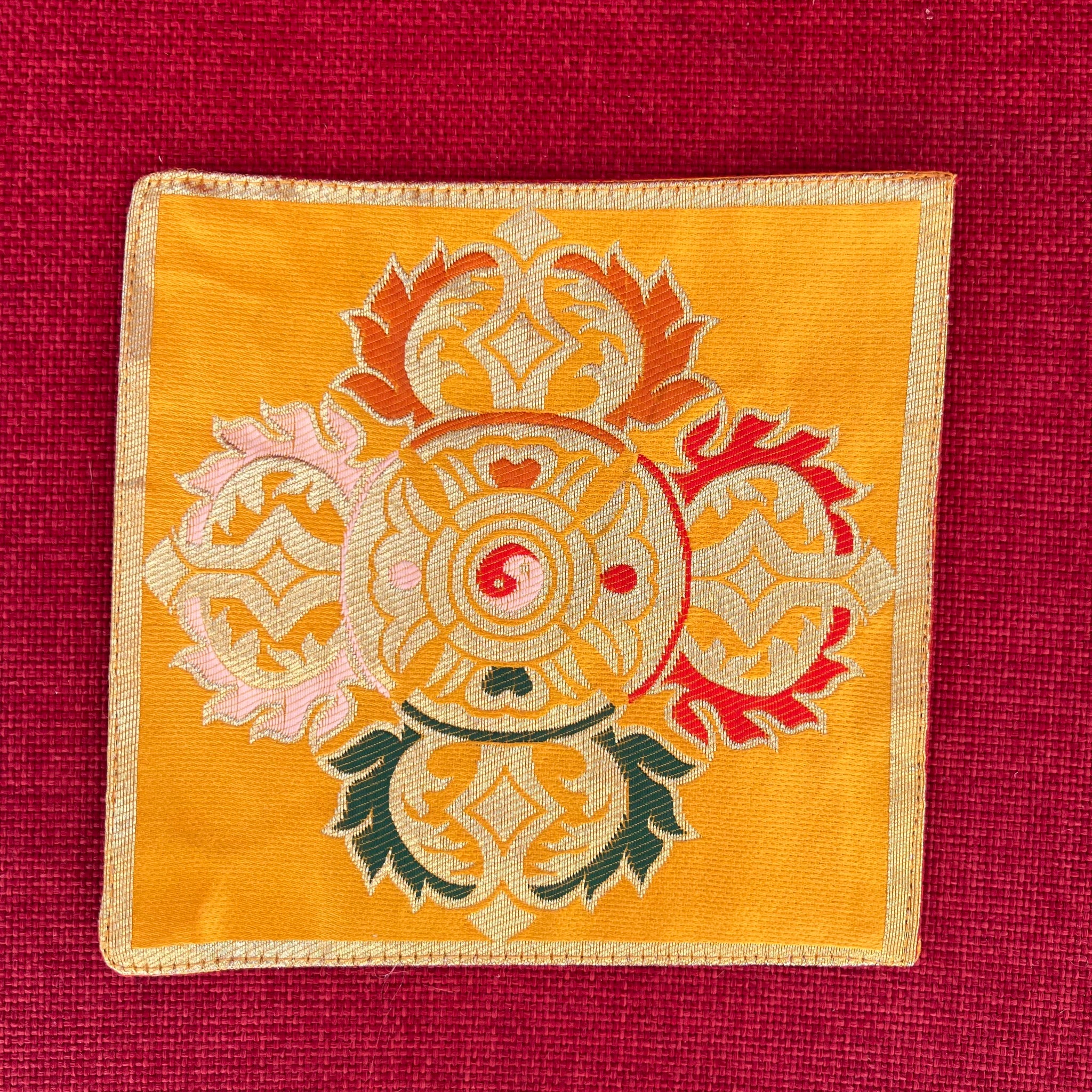 Yellow brocade Bell and Dorje mat with double dorje in centre