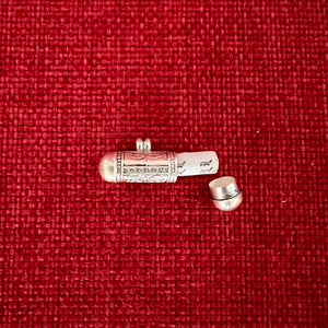 2.3cm long silver horizontal cylinder locket embossed with Tibetan Om, Buddha Eyes and the dorje symbol and contains scroll with Om Mani Padme Hung mantras inside