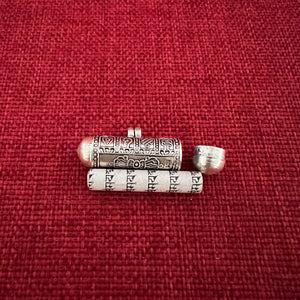 4cm long silver horizontal cylinder locket embossed with 8 auspicious symbols and dorje and scroll with Om Mani Padme Hung mantras inside