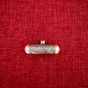 4cm long silver horizontal cylinder locket embossed with 8 auspicious symbols and dorje and scroll with Om Mani Padme Hung mantras inside