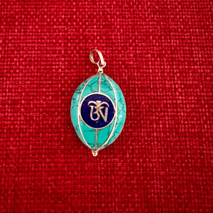 Coloured silver pendant with Tibetan OM symbol on one side and the Endless Knot symbol on the other side