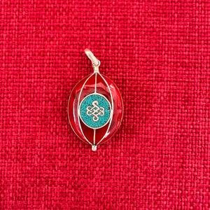 Red coloured silver pendant with Tibetan OM symbol on one side and the Endless Knot symbol on the other side