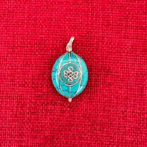 Coloured silver pendant with Kalachakra symbol on one side and the Endless Knot symbol on the other side
