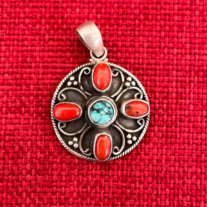 3cm round sterling silver pendant with turquoise and coral stones in the symbolic shape of a Double Dorje