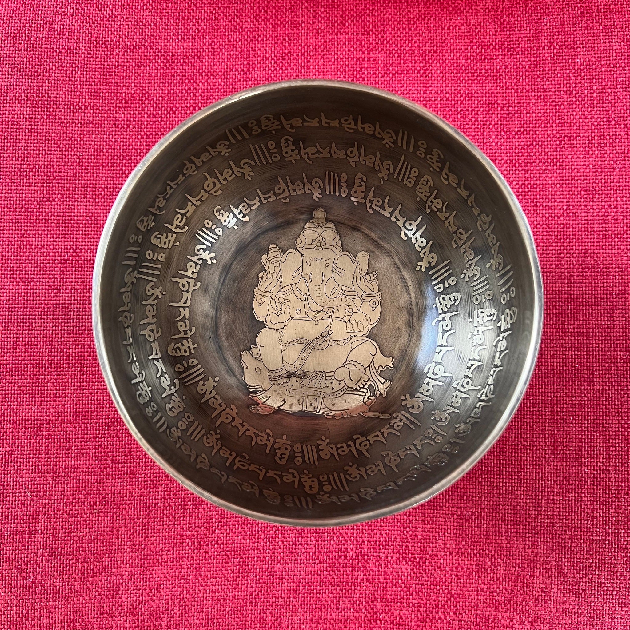 14cm singing bowl with etched image of Ganesh on the inside and the om mani padme hung mantra around the outside